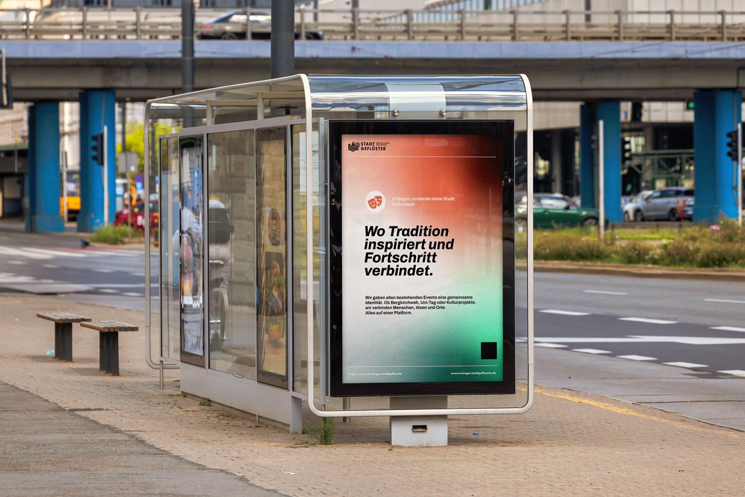 Eine Bushaltestelle zeigt eine plakatierte Wand mit dem Design von der Stadtinitiative "Stadtgeflüster". Im Hintergrund ist eine Brücke mit Straßenunterführung.